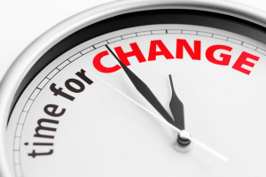 Close-up of a clock showing the words "Time For Change". Shallow depth of field.